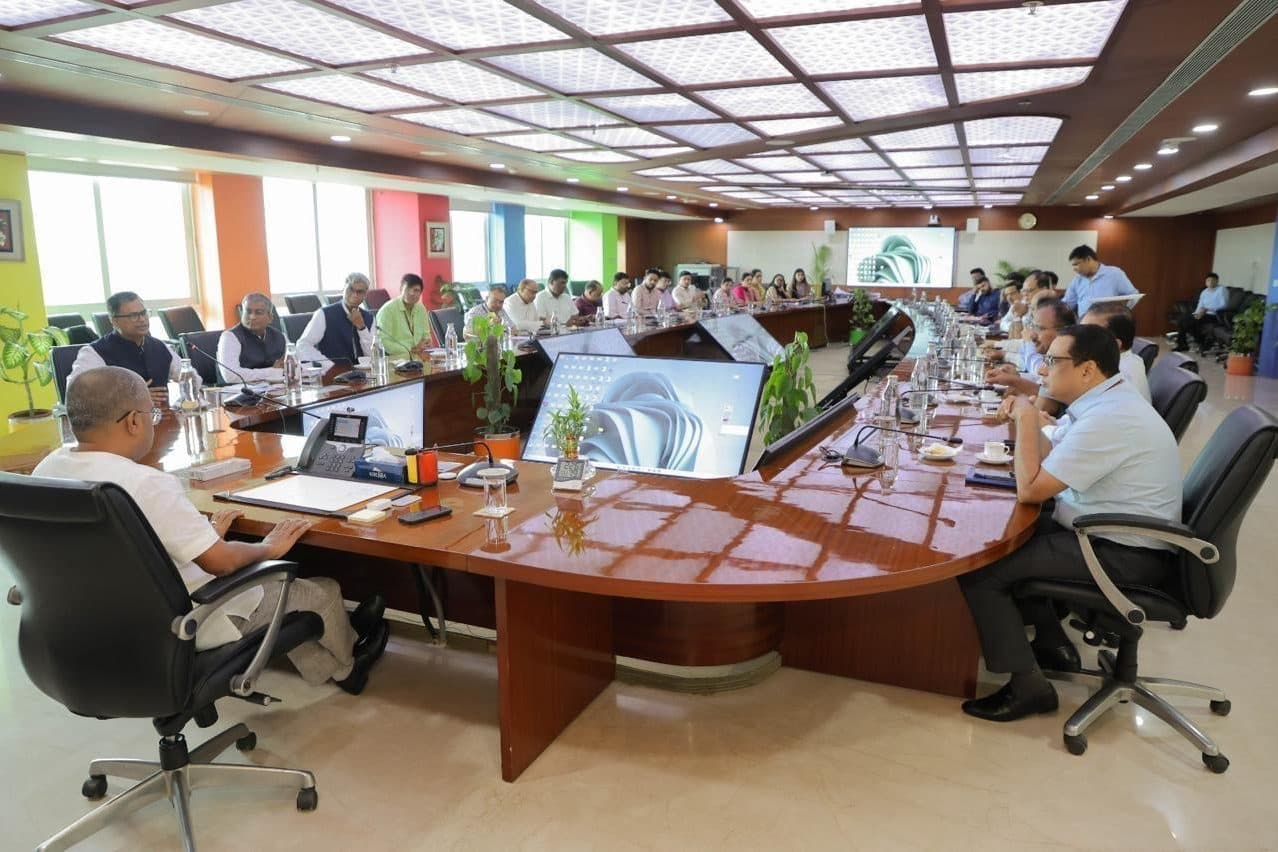 Officials seated around a large curved boardroom table during a meeting