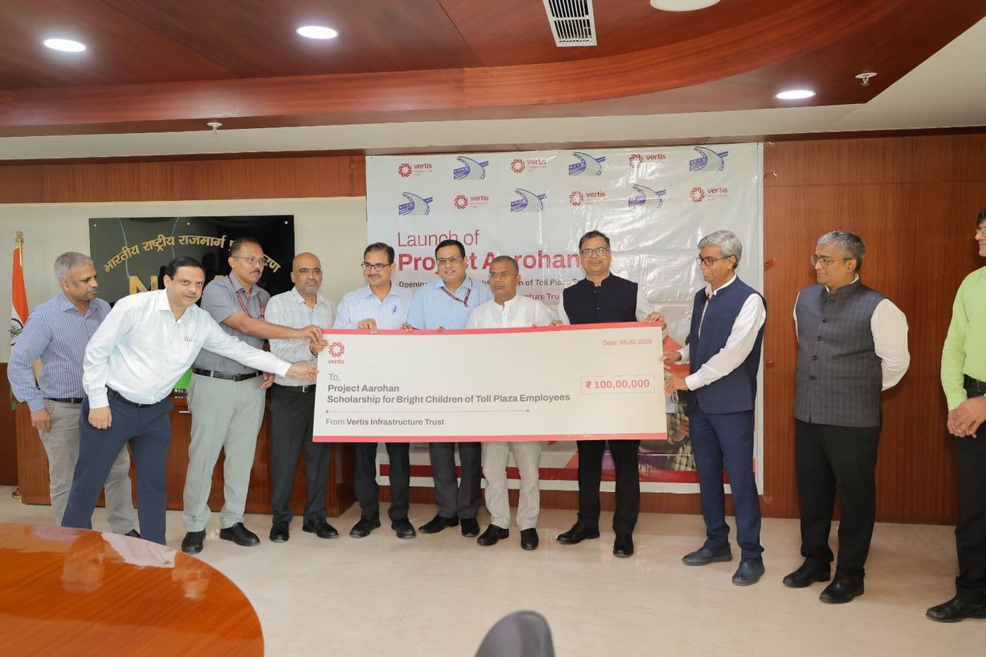 A line of officials holding an oversized ceremonial cheque together in front of the launch banner